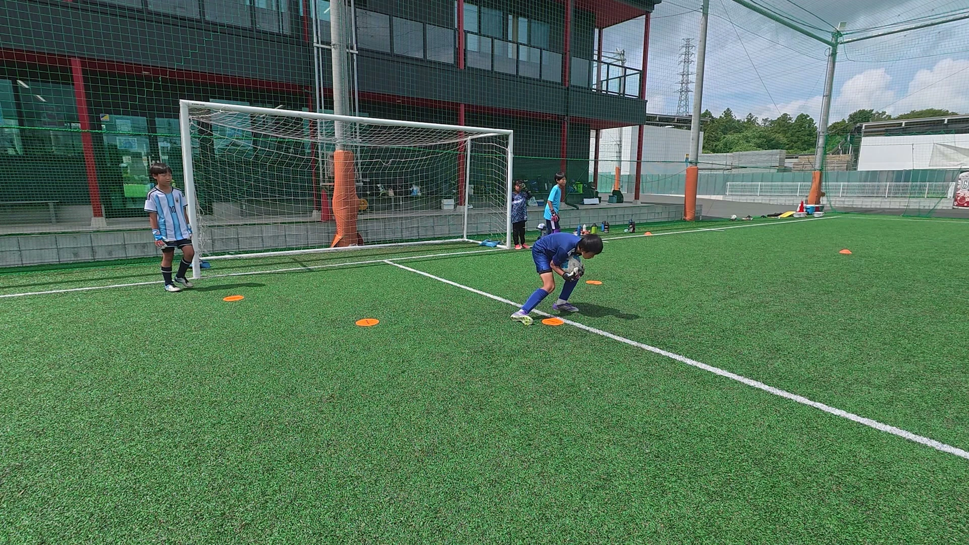 フューチャーGKキャンプで低い位置のボールを両手で捉えるゴールキーパー